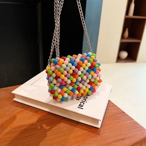 Close-up of a colorful beaded mini crossbody bag with a silver metal chain strap
