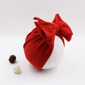 Detailed view of red infant headband with large bow on white model head model