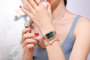 Detail of elegant Yolako watch featuring a green square dial and rose gold mesh strap