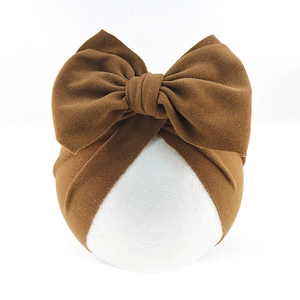 Detailed texture of a dark brown velvet bow headband for infants and young girls