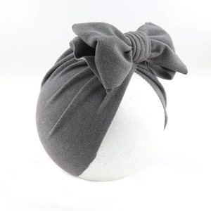 Detail of grey bow headband with pleated velvet fabric on a display model head