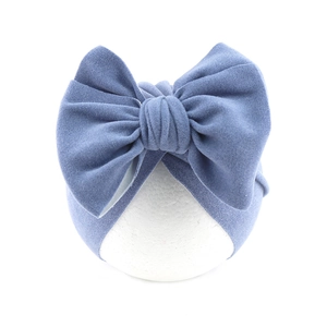 Detail shot of the large decorative bow and soft denim blue fabric on baby turban hat
