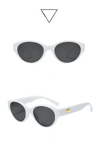 Vue détaillée de lunettes œil de chat blanches avec verres gris et détails dorés