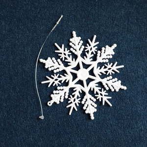 White plastic snowflake ornament with hanging string for Christmas tree decor