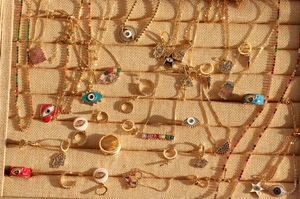 Close-up of golden charms with rainbow zircon and evil eye motifs on display