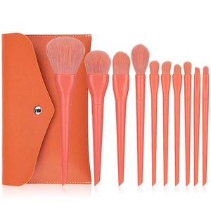 Detail of 12 candy-colored makeup brushes with a matching orange leather storage case