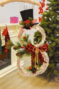 Close-up of snowman Christmas wreath with natural rattan and glowing LED lights décor