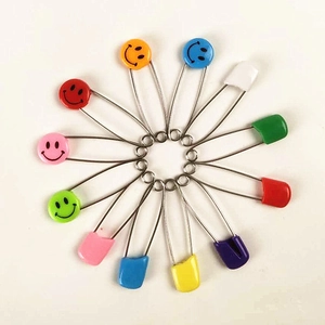 Spille di sicurezza colorate con faccine e teste in plastica disposte in cerchio
