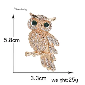 Detailed owl brooch with sparkling rhinestones and green eyes, size 5.8cm by 3.3cm