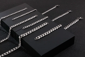 Polished silver stainless steel Cuban link chains displayed on a professional black stand