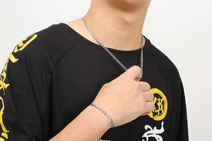 Men's silver stainless steel Cuban link necklace and bracelet set on male model