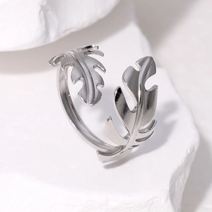Minimalist silver leaf stainless steel open ring displayed on white textured stone