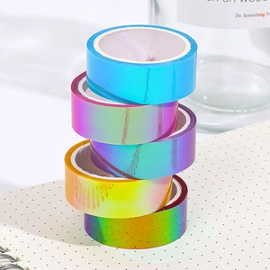 5 rolls of colorful holographic laser washi tape with rainbow gradient on a dotted notebook