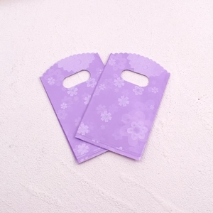 Macro detail of purple plastic jewelry bags featuring delicate cherry blossom prints