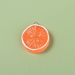 Macro shot of resin orange slice charms with silver loops for DIY jewelry making