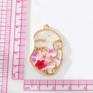 Face silhouette resin pendant with real dried flowers and gold metal frame detailing