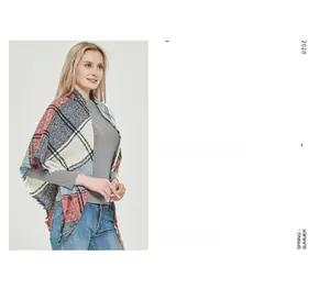 Detail of red and blue tartan plaid shawl with fringe edges on a female model
