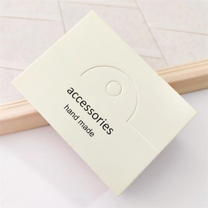 Close-up of cream jewelry display card with hand made accessories text engraving