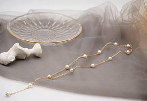 Close-up of elegant Y-shaped adjustable pearl necklace with delicate gold chain