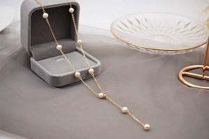 Detailed view of adjustable gold-plated necklace with elegant freshwater pearls on velvet