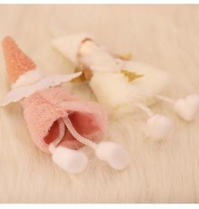 Detail of pink and beige plush angel ornaments with knit hats and faux fur wings