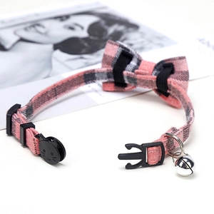 Detailed view of pink plaid pet collar with bowknot, silver bell and cat face buckle