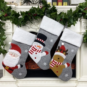 Set of 3 grey felt Christmas stockings with Santa and reindeer on a white fireplace