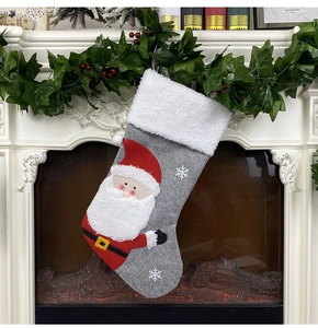Detail of grey felt Christmas stocking with 3D Santa and snowflake on a festive mantel