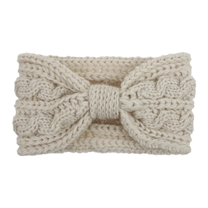 Détail d'un bandeau en maille torsadée blanc crème avec un nœud central pour l'hiver