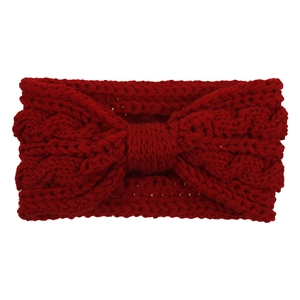 Détail de la texture d'un bandeau en maille rouge foncé avec un nœud décoratif