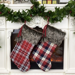Classic plaid Christmas stockings with plush faux fur cuffs hanging on a festive fireplace