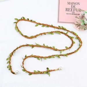 Detail of woven leaf tassel belt featuring green faux leaves and large white pearls