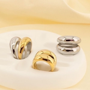 Macro shot of chunky gold and silver plated titanium steel rings on white pedestal