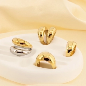 Polished 18k gold and silver thick dome rings on minimalist wave jewelry display