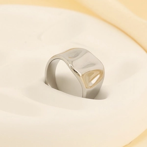 Macro detail of silver geometric lava ring showing irregular hammered metal texture