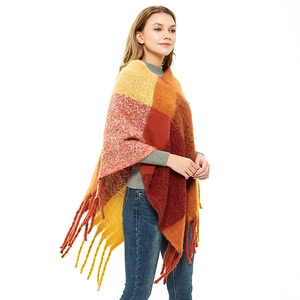 Women's plaid poncho shawl with thick tassels and warm autumn pattern on white background
