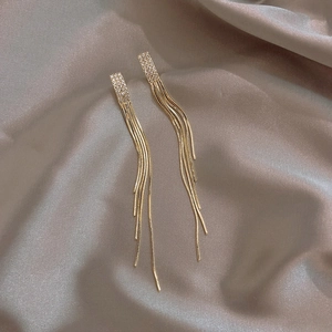 Macro di orecchini a nappa dorati con rettangoli di strass su seta grigia pregiata