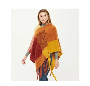 Close-up of color-block plaid knit poncho with fringes in warm yellow and red tones