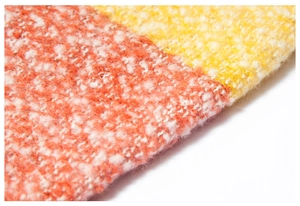 Macro shot of plaid poncho fabric with orange and yellow boucle yarn texture