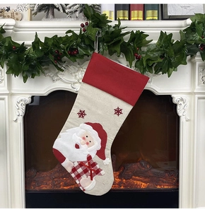 Hanging large Santa Claus Christmas stocking with red cuff on festive fireplace background