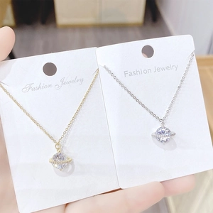 Macro shot of Saturn pendant necklaces with sparkling zircons in gold and silver plating