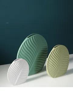 Close-up of ceramic leaf-shaped vases with detailed vein texture in matte finish