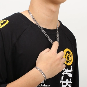 Polished silver stainless steel chain necklace and bracelet set worn by a model