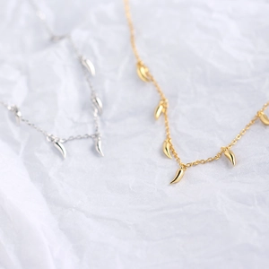 Makroaufnahme von S925 Sterlingsilber-Halsketten mit kleinen Pfeffer-Anhängern in Gold und Silber