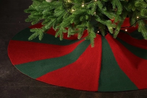 Close-up of red and green knitted Christmas tree skirt with festive pattern texture