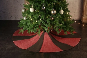 Detail of red and dark brown knitted stripe Christmas tree skirt in a cozy home setting