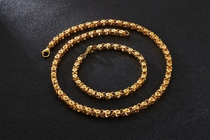 Close-up of gold stainless steel necklace and bracelet set with floral ring links