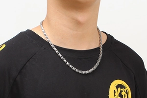 Close-up of a men's silver stainless steel Cuban link necklace with sparkling crystals