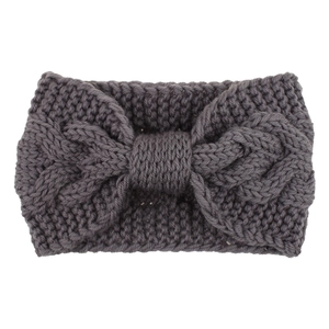 Detail of dark grey knit headband with chunky cable texture and oversized bow design