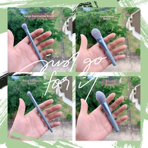 Detail view of 8pcs mini makeup brush set with blue metallic handles and soft grey bristles